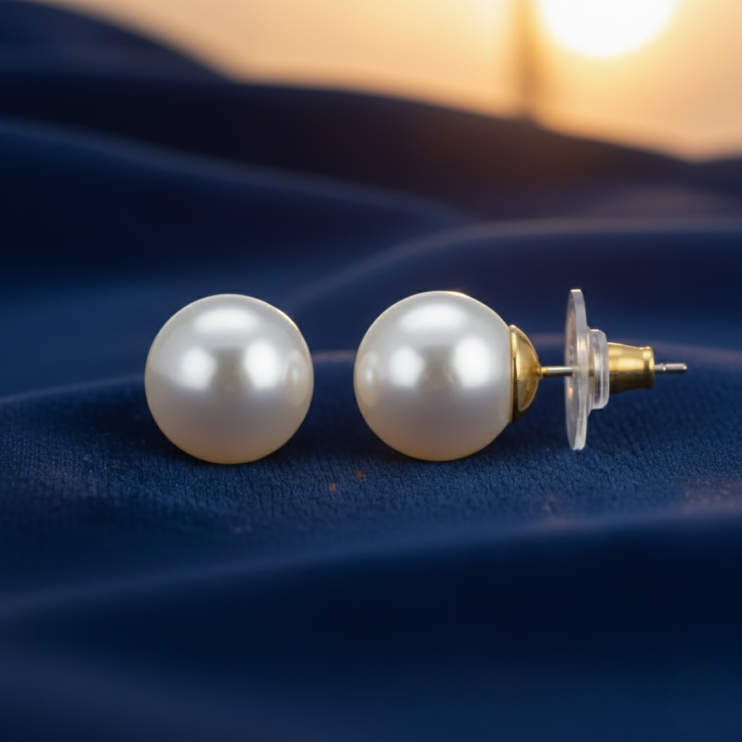 Pearl earrings on a blue fabric background