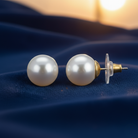 Pearl earrings on a blue fabric background
