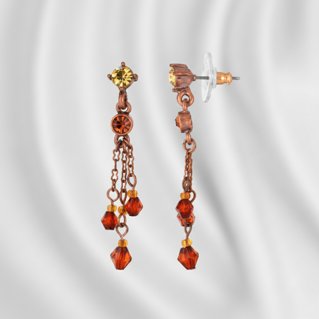 Pair of copper and amber crystal earrings on a white background
