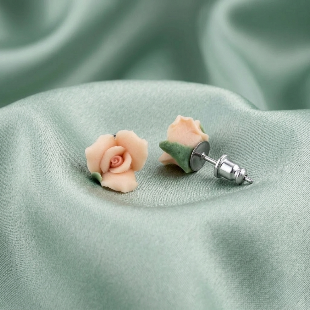 Floral porcelain rose earrings on a soft green fabric background