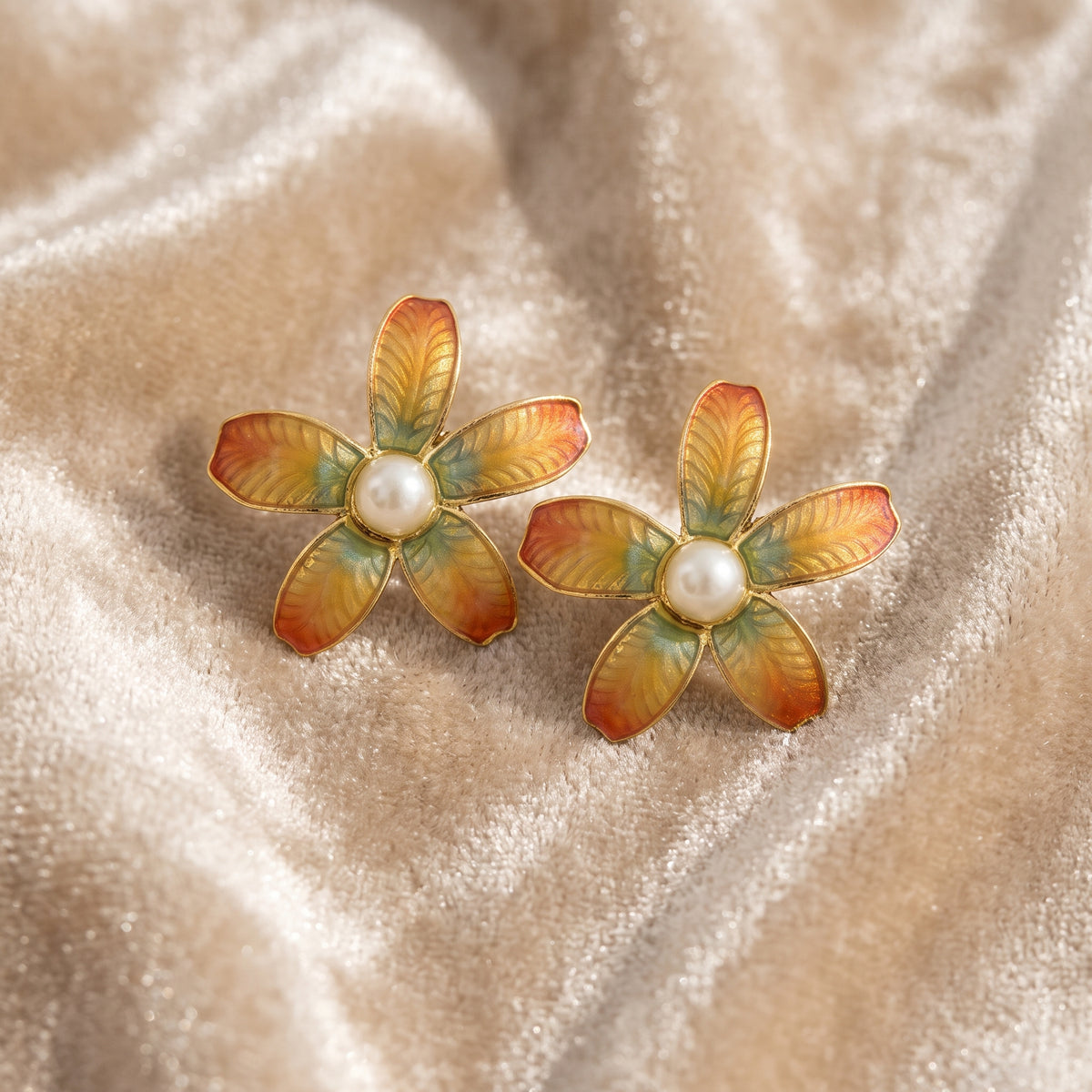 Antiquities Couture Fantasia Fiori Faux Pearl Floral Earrings resting on champagne colored velvet fabric