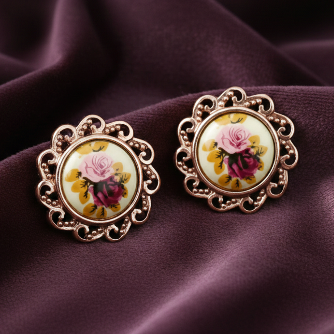 Pair of floral earrings on a purple fabric background