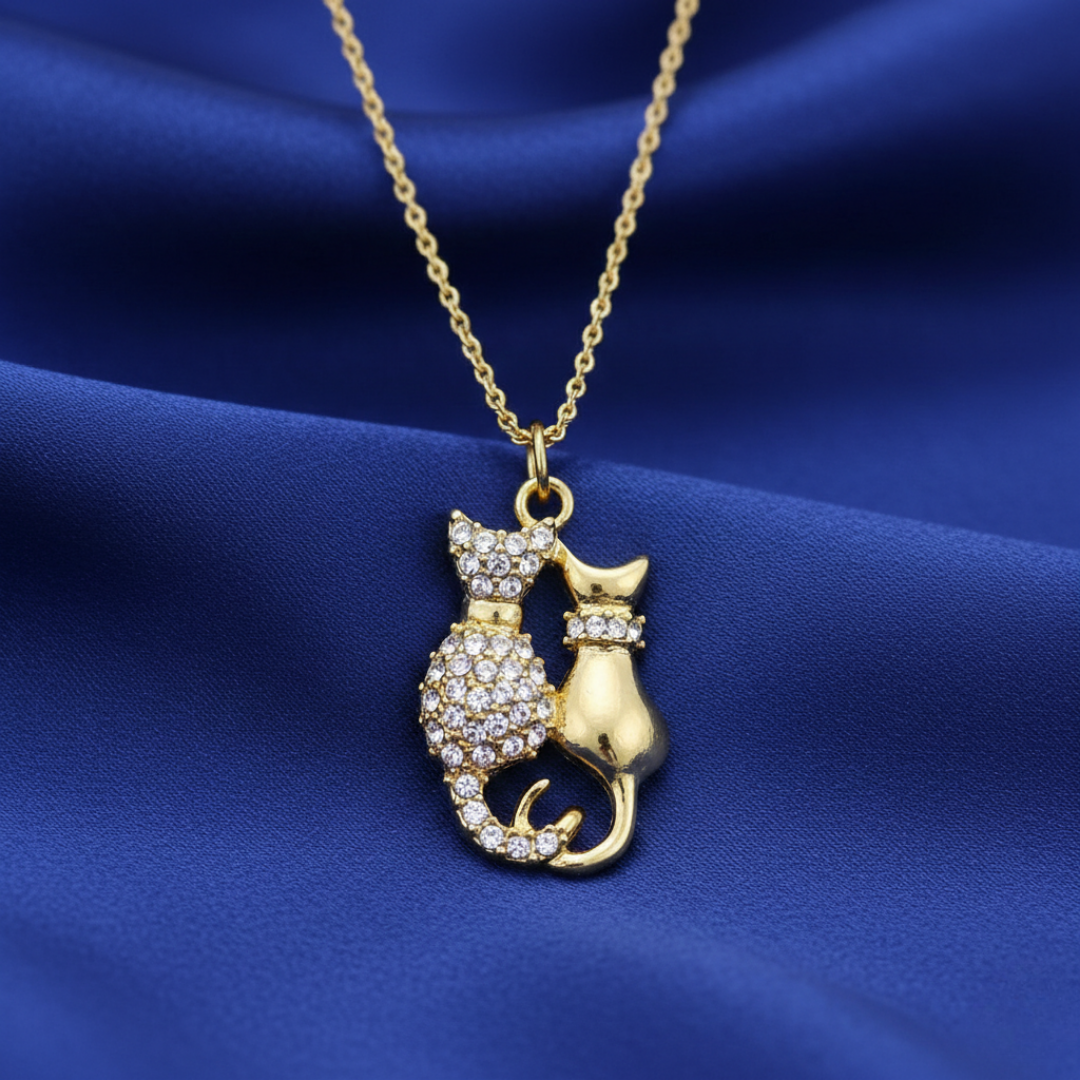Gold cat-shaped pendant necklace on a blue fabric background