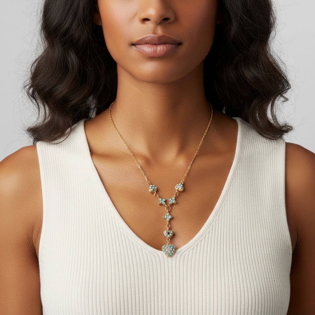 Woman wearing a gold necklace with turquoise stones against a neutral background