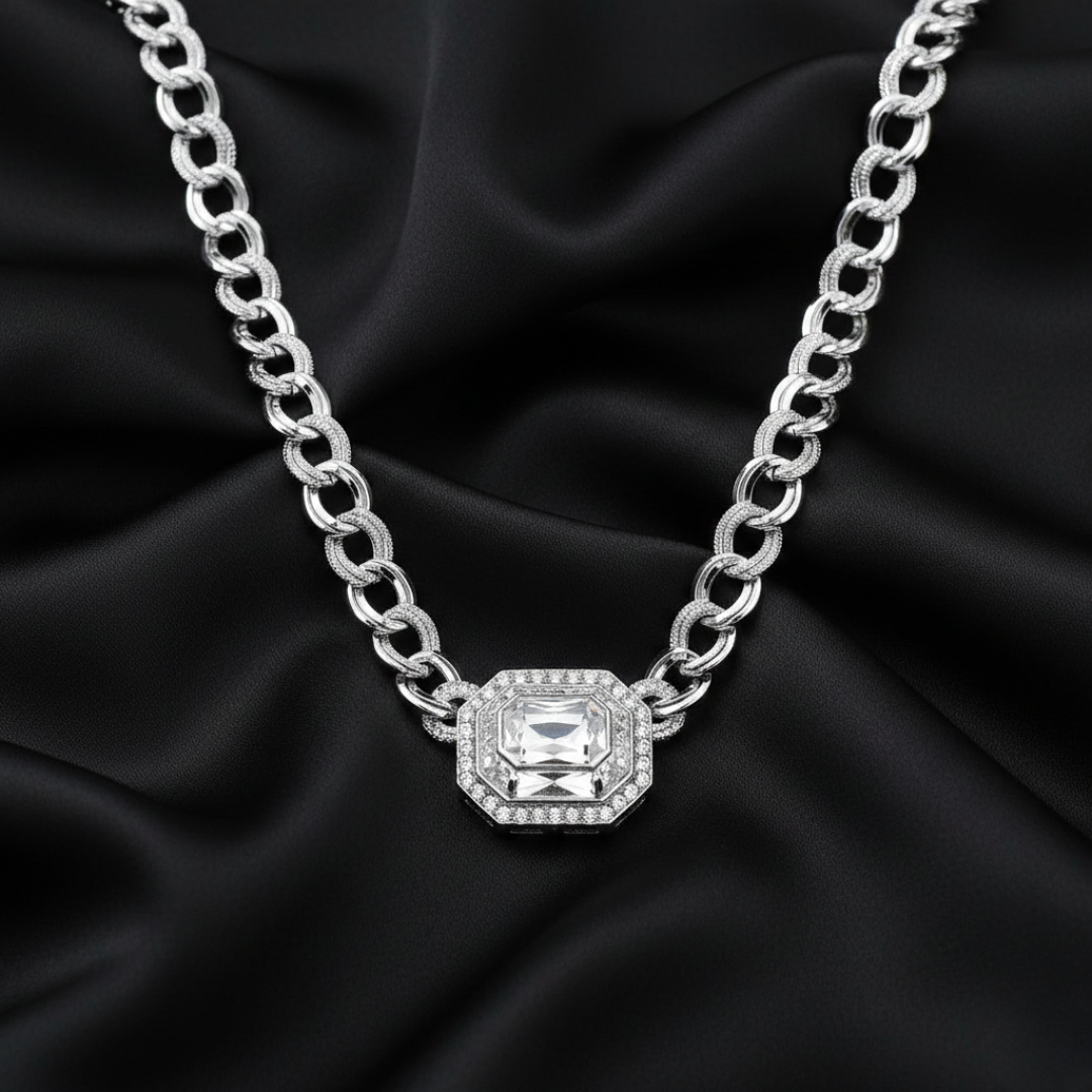 Silver chain necklace with a crystal pendant on black fabric