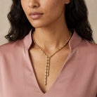 Woman wearing a Gold Fancy Link Chain Drop Necklace with a pink blouse against a neutral background