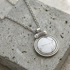 White Howlite Gemstone Pendant Necklace on a textured stone surface
