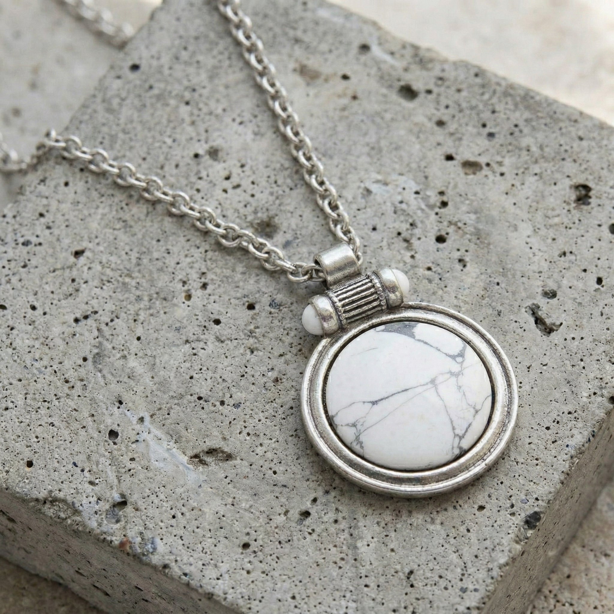 White Howlite Gemstone Pendant Necklace on a textured stone surface