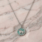 Turquoise Color Enamel Horse Pendant Necklace on a marble surface