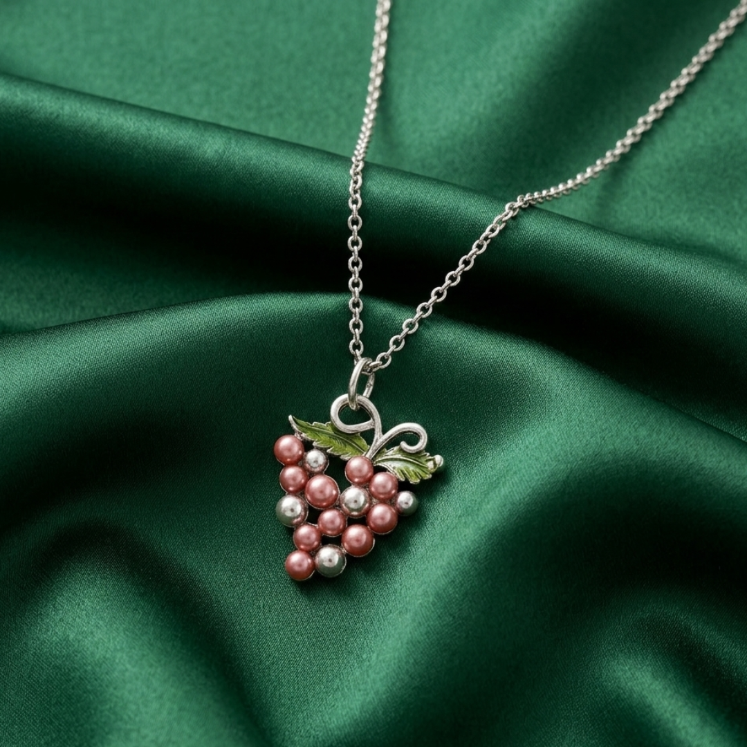 Necklace with a wine grape pendant on a green fabric background