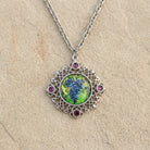 Winery Purple Grapes Decal And Filigree Pendant Necklace 16" + 3" Extender displayed on a textured beige stone surface.