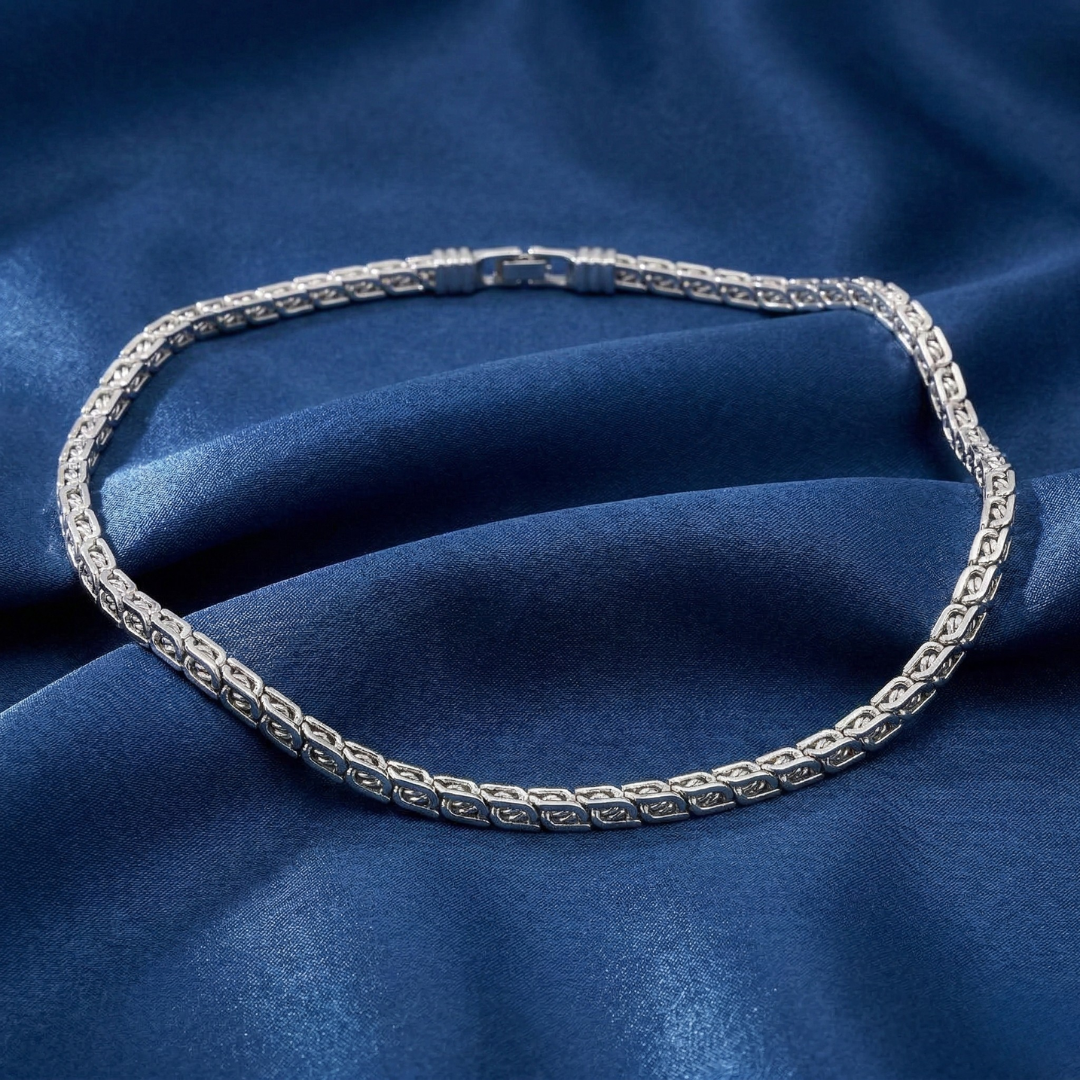 Silver necklace on a blue fabric background