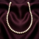 Pearl necklace on a purple fabric background