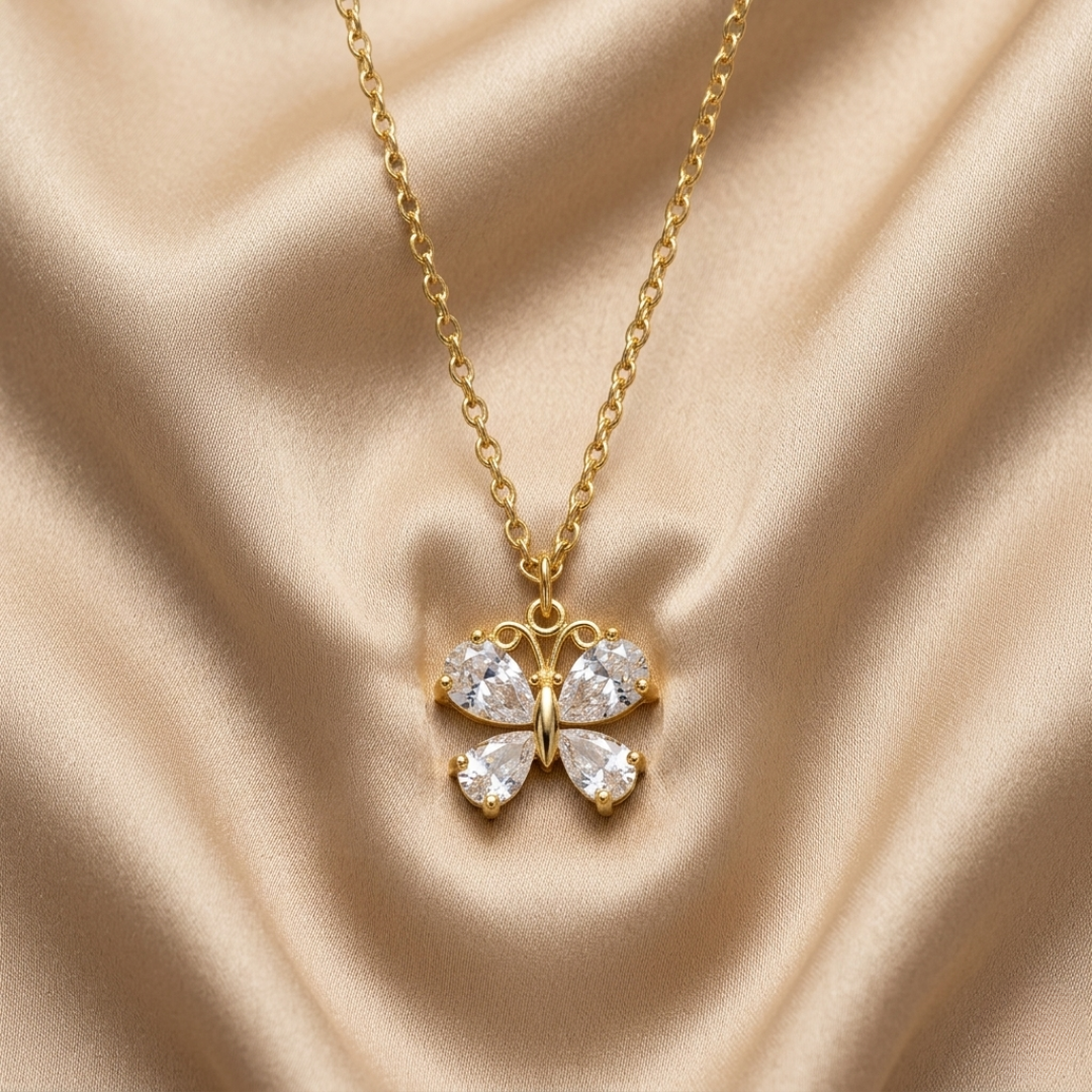 Gold necklace with a butterfly-shaped pendant on a beige fabric background
