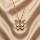 Gold necklace with a butterfly-shaped pendant on a beige fabric background