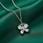 Butterfly-shaped pendant necklace on a green fabric background