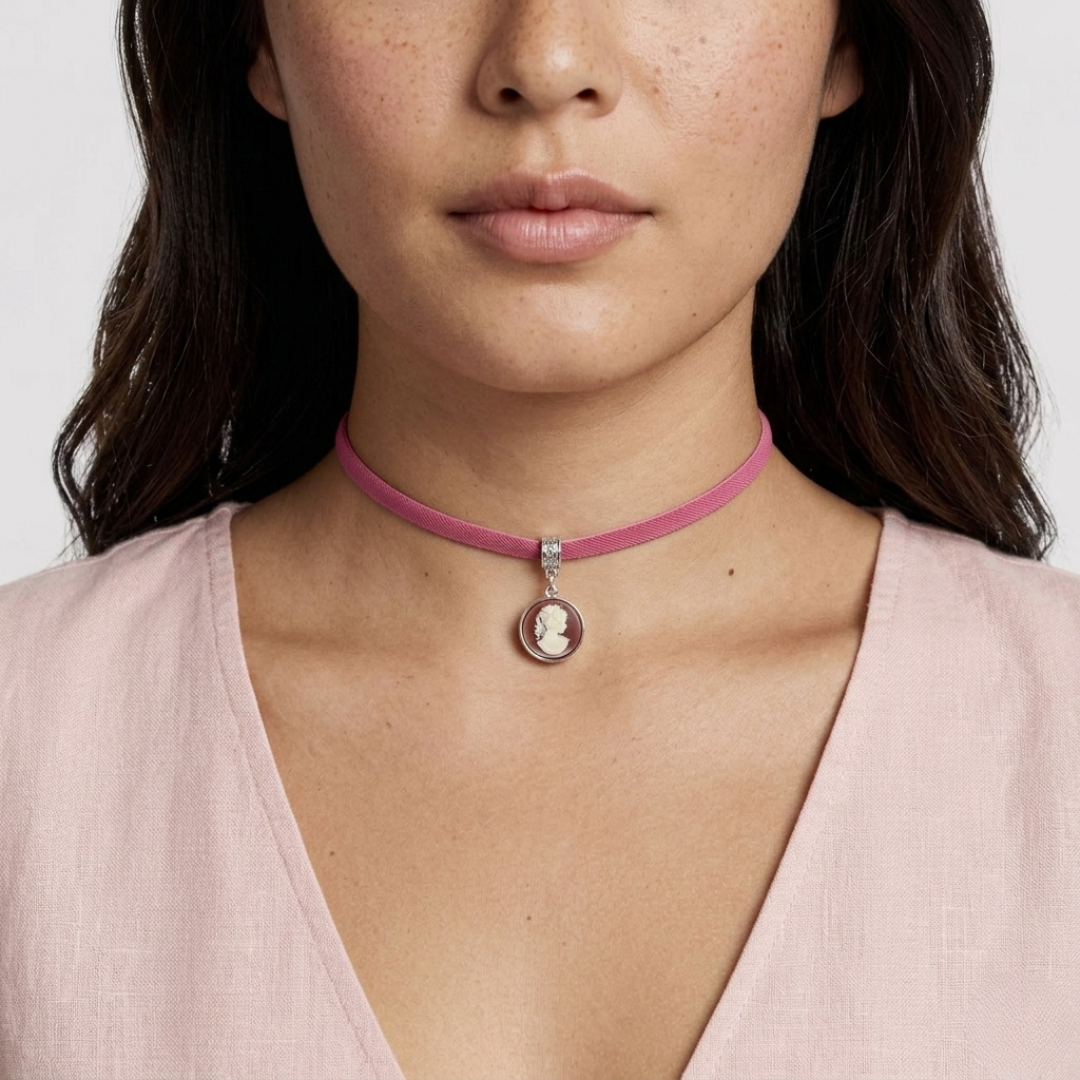 Close-up of a woman wearing a red choker necklace with a cameo pendant.