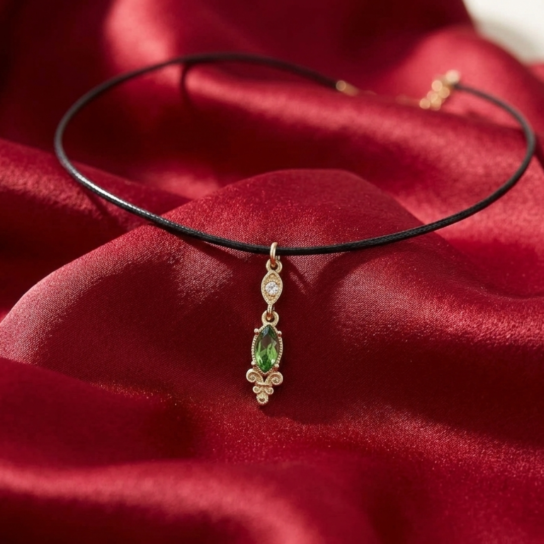 Necklace with a green crystal pendant on a red fabric background