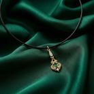Necklace with a gold pendant on a green fabric background