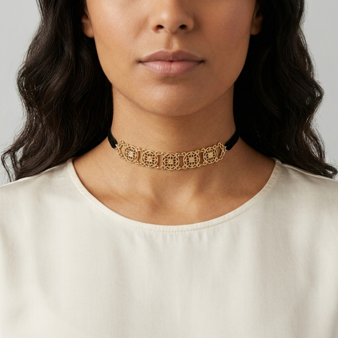 Woman wearing a gold choker necklace against a neutral background
