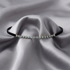 Delicate choker necklace with small blue crystals on a gray fabric background