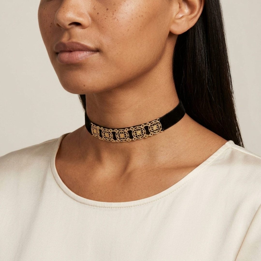 Woman wearing a black choker with gold detailing on a neutral background