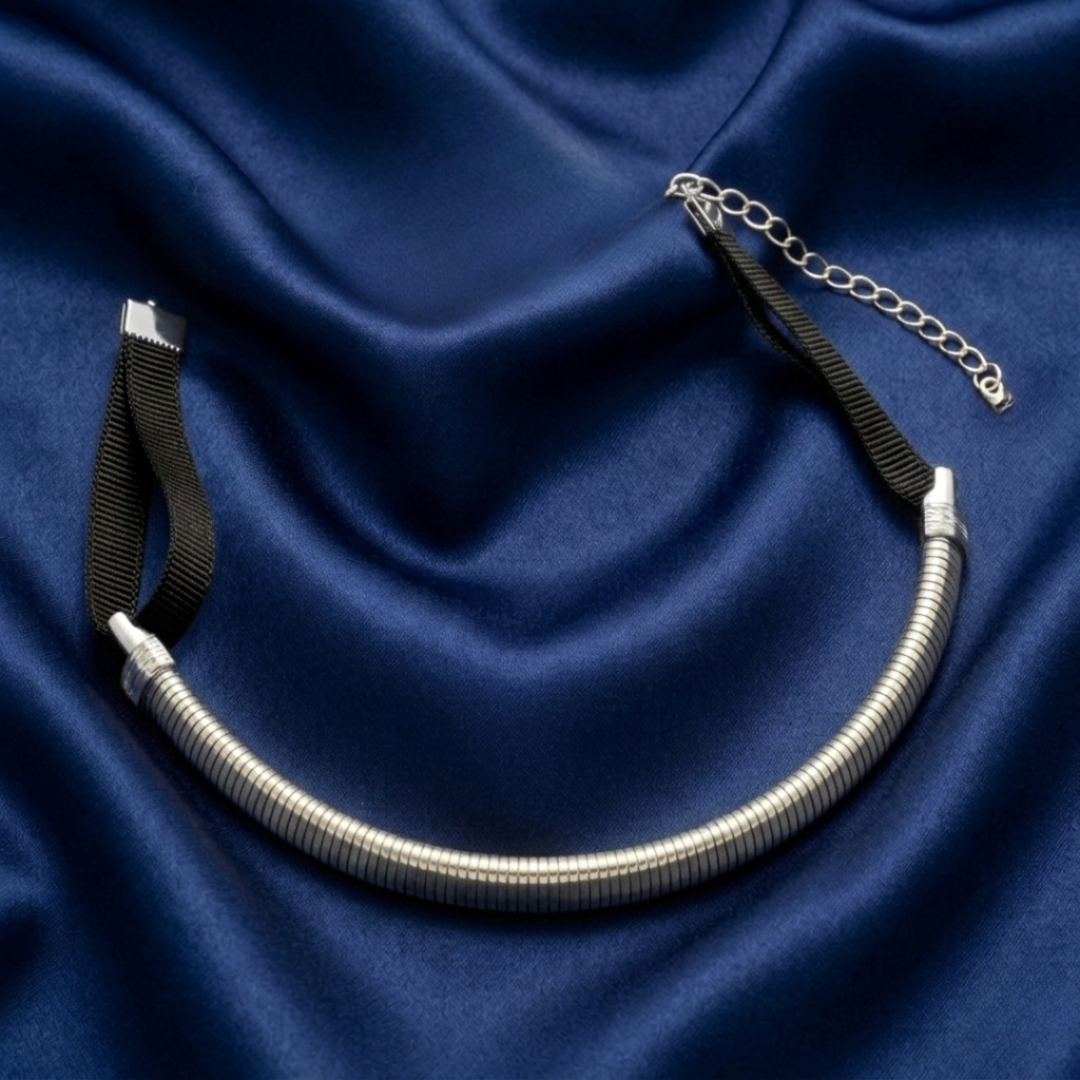 Silver choker necklace on a blue fabric background