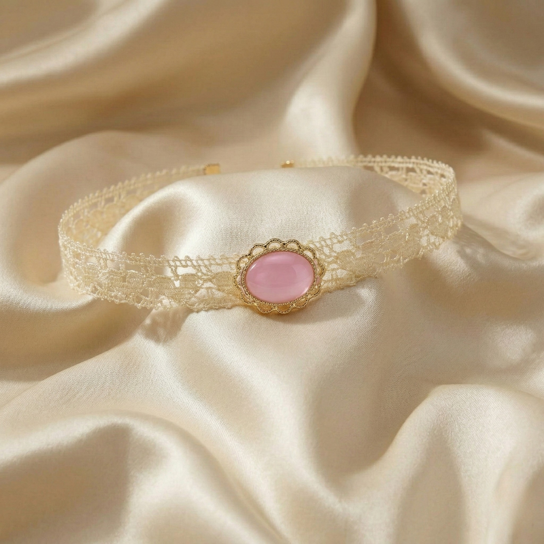 Delicate lace choker with a light pink stone on a beige fabric background