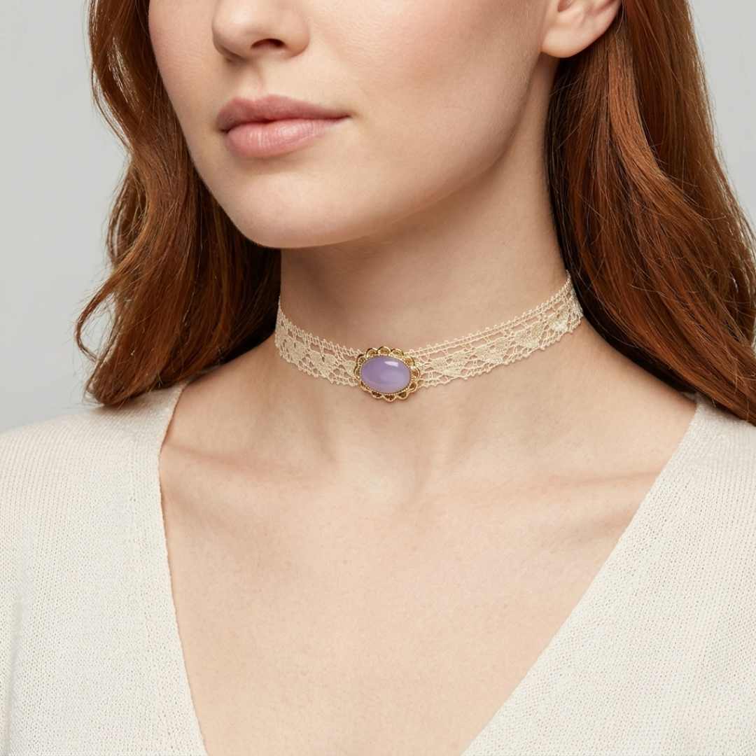 Close-up of a woman wearing a gold choker necklace with a purple gemstone on a neutral background
