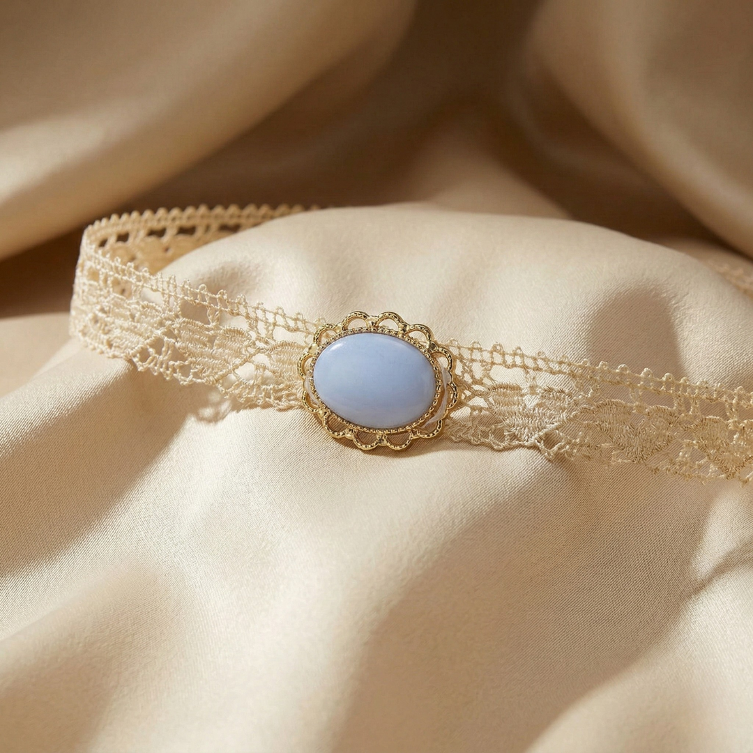 Delicate lace choker with a light blue stone on a beige fabric background