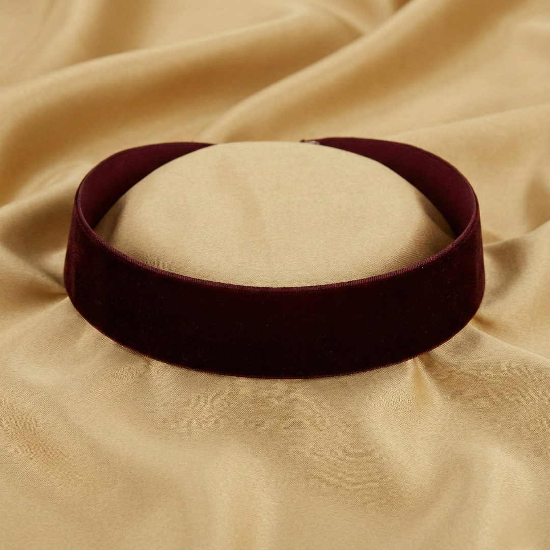Burgundy velvet choker necklace on a beige fabric background