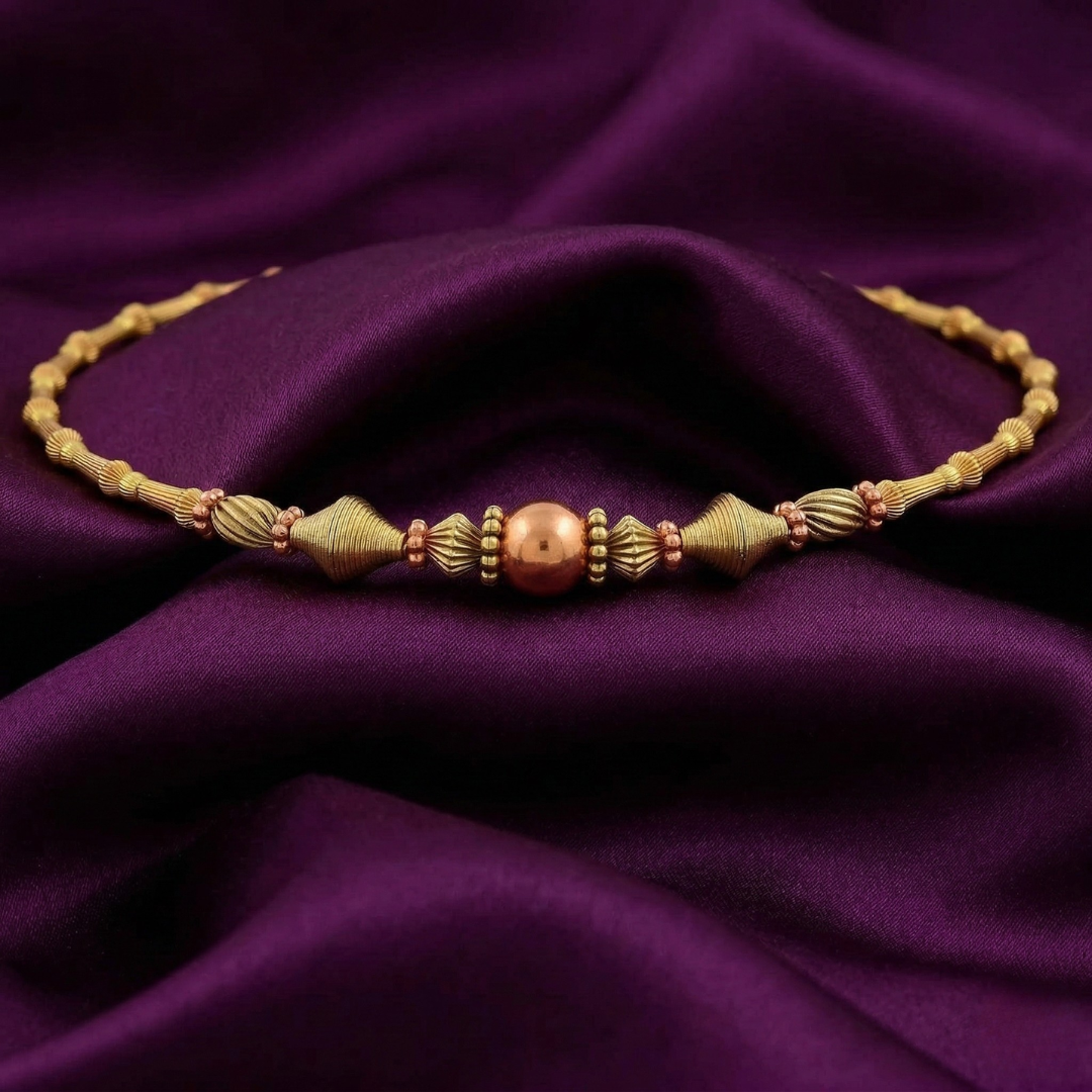 Gold beaded choker necklace on purple fabric