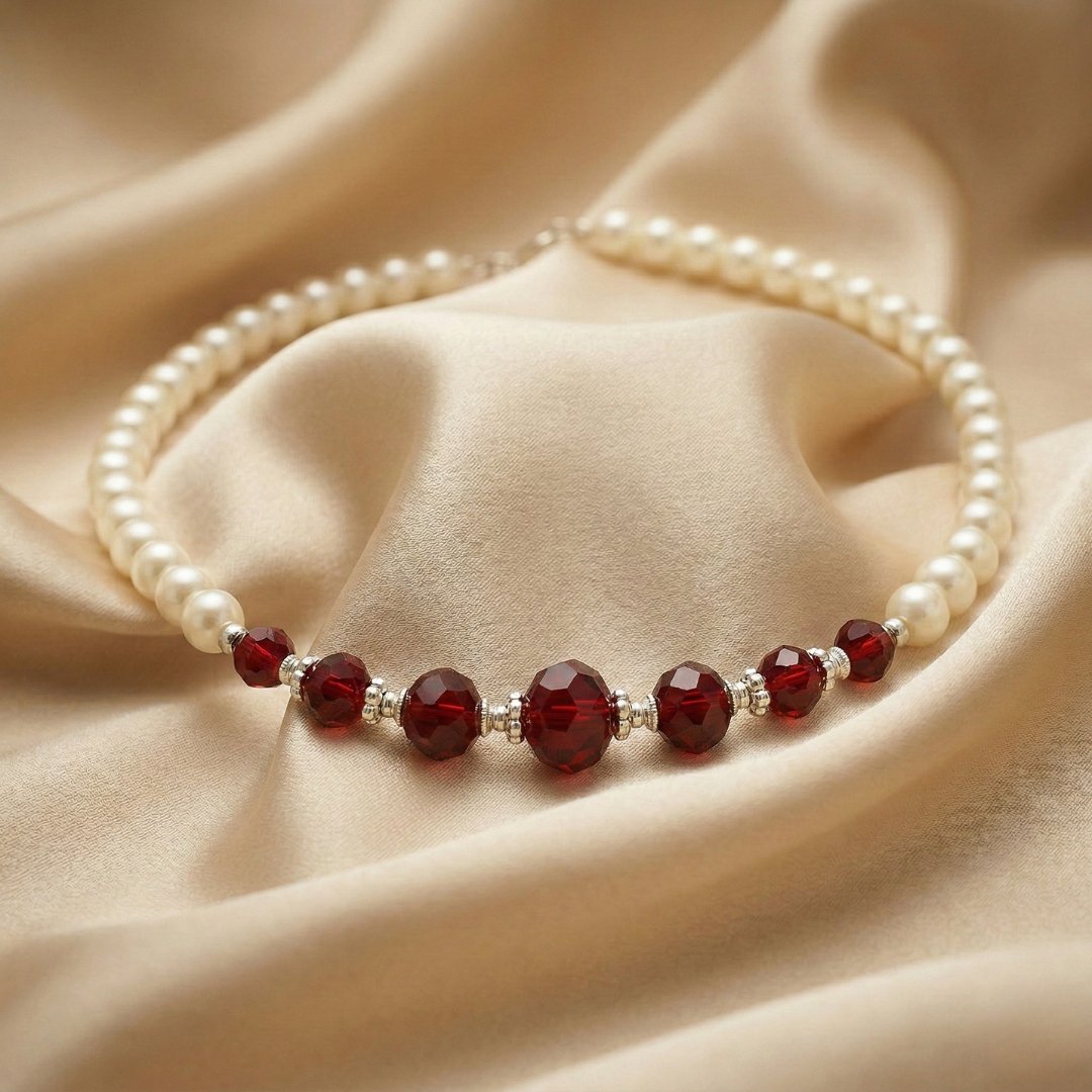 Pearl bracelet with red beads on a beige fabric background