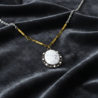 Necklace with a white pendant on a dark fabric background