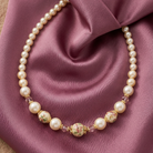 Pearl necklace with floral beads on a purple fabric background