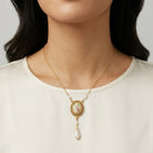 Oval Flower Decal Faux Pearl Teardrop Pendant Necklace worn by a person on a plain background