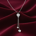 Silver heart-shaped necklace on a burgundy fabric background