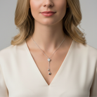 Woman wearing a delicate necklace with a neutral background
