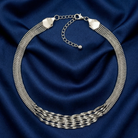 Silver necklace on a blue fabric background