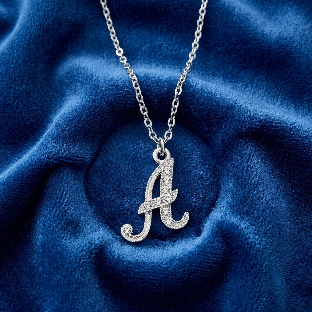 Silver necklace with a letter 'A' pendant on a blue fabric background