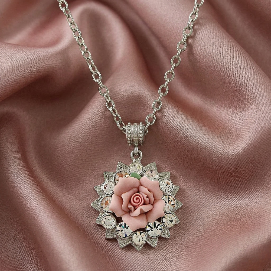 Necklace with a floral porcelain rose pendant on a pink satin background