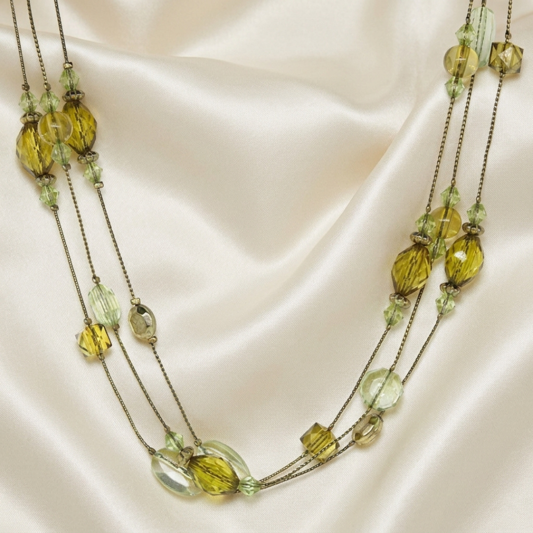 Necklace with olivine green beads on a satin background