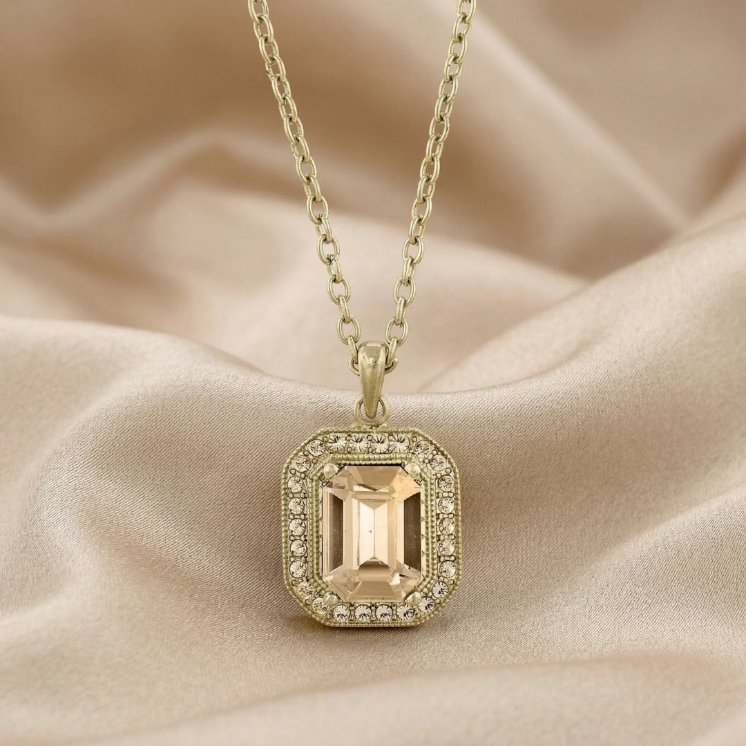 Gold necklace with a pendant on a beige fabric background