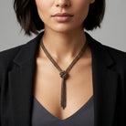Model in a black blazer wearing our Eclipse Black And Gold Chain Tassel Knotted Necklace 16" + 3" Extender
