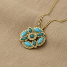 Necklace with a turquoise pendant on a beige fabric background