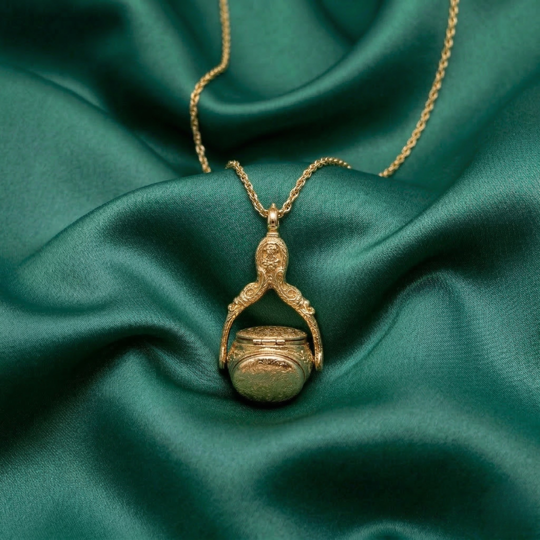 Gold necklace with a spinner pendant on a green fabric background