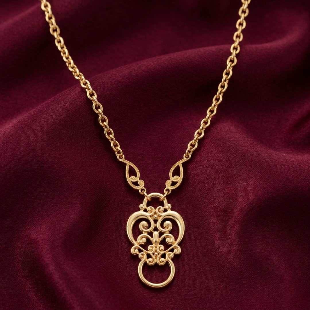 Gold eye glass holder necklace with a decorative pendant on a maroon fabric background