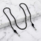 Black Chain And Black Eyeglass Holder Chain Necklace resting on white marble stone