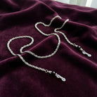 Scroll Chain Black Bead Eyeglass Holder Chain Necklace on a maroon fabric background