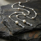 Faux Pearl Eyeglass Holder Chain Necklace on a dark stone surface